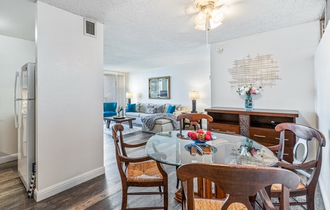 The dining area features a glass table and comfortable seating, seamlessly connecting to the living space, perfect for casual meals or entertaining.