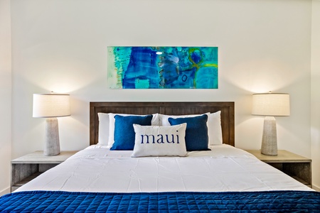 The primary bedroom at Kapalua Ridge 1421 features a plush king bed with vibrant blue accents for ultimate relaxation.