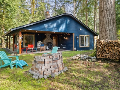 Freshly stacked firewood and charming cabin vibes greet guests upon arrival to this forested retreat.