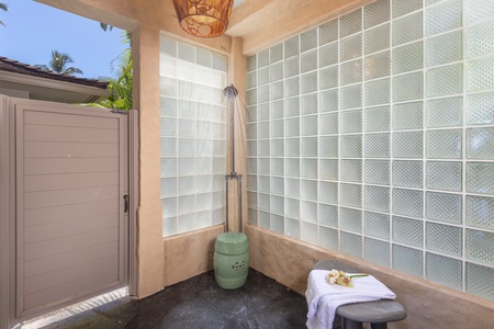 Private outdoor shower garden framed by glass-block walls.