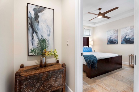 Charming entryway leading to the second guest bedroom enhanced by striking artwork and vintage furniture.