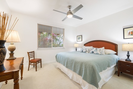 The calming primary suite features a king-size bed, ceiling fan, and serene garden views—your private retreat after a beach day.