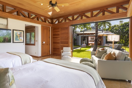 The second guest suite overlooks a cozy shaded lounging area next to the pool, leading to the primary bedroom