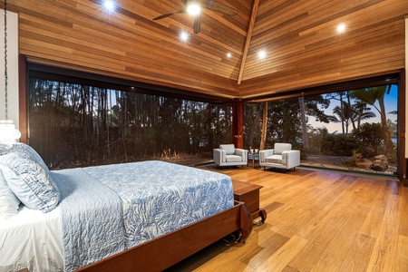 Wake up in your serene retreat with floor-to-ceiling windows framing tropical views and warm wood creating the perfect peaceful sanctuary.