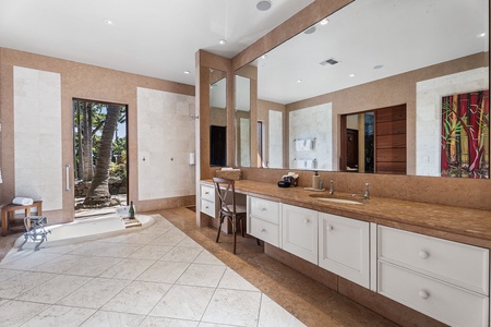 Luxurious spa-like bathroom featuring elegant stone counters, spacious vanity, and serene garden views for your perfect morning routine.
