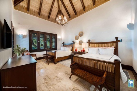 Retreat in this charming bedroom featuring two cozy beds and a TV.