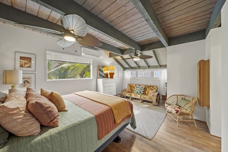 Spacious loft-style suite with exposed beams and natural light, perfect for a restful stay.