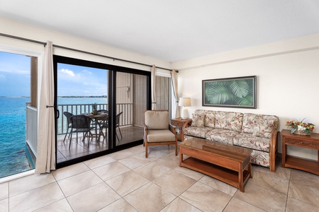 Relax after a day in Kona in the cozy living area with plush sofa sleeper, ceiling fan, and flat-screen TV.