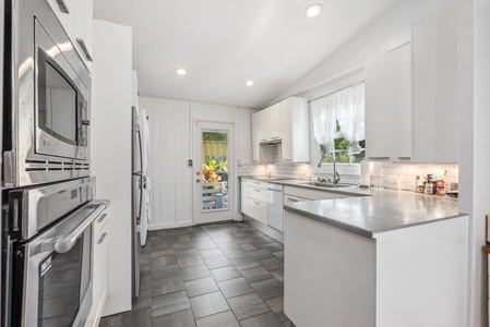 Modern and well-equipped kitchen with counter spaces and easy outdoor access to enjoy the island breeze.