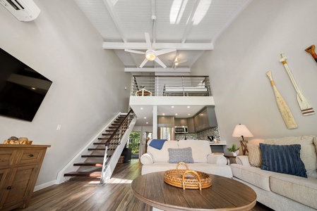 Living room with custom staircase and railing, split AC and remodeled kitchen