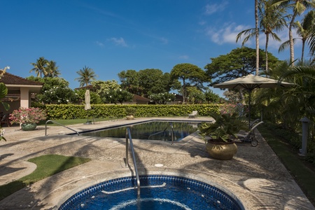 Relax in the hot tub with sparkling blue waters and tropical gardens creating the perfect outdoor sanctuary.