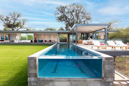 Sleek pool with clear views to a modern, open-plan home.