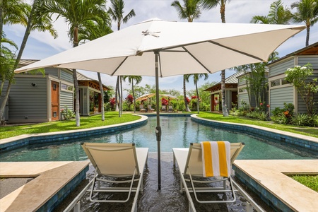 100-foot pool with loungers, coconut trees, and stunning views at Pauoa Beach Club