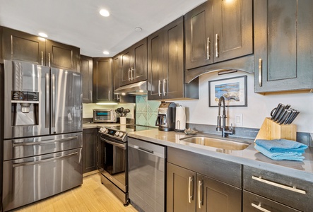 This modern kitchen features sleek cabinetry and stainless steel appliances, providing a perfect space for preparing meals with ease during your stay.