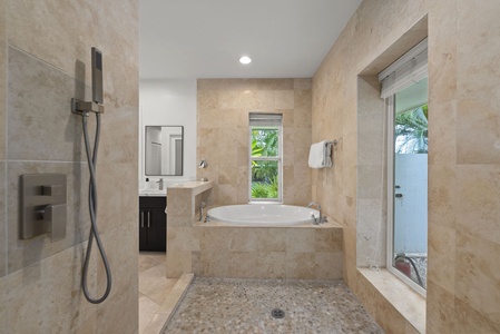 Primary bath with spa-inspired shower and deep tub, a private wellness haven.