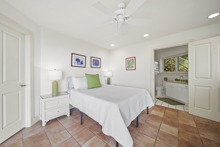 Rest peacefully in this bright guest bedroom with a queen bed, crisp linens, tropical art, and your own private kitchenette for morning coffee.