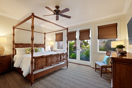 The primary bedroom at Unit B111 features a four-poster bed, direct access to a lanai, and a relaxing ambiance.