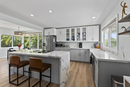 Modern and spacious, this fully equipped kitchen features sleek countertops and a breakfast bar.