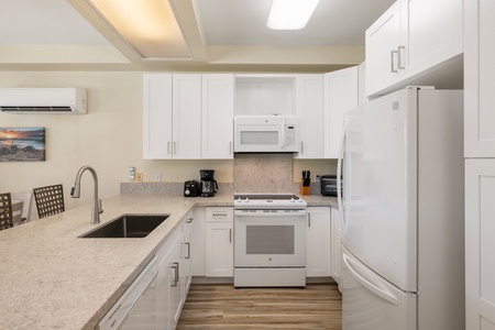 The bright kitchen features a fridge, oven, extended counter-tops and bar seating.