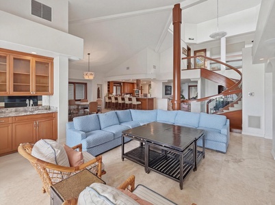 Relax in this stunning open-plan living space with soaring ceilings, elegant spiral staircase, and comfortable seating perfect for unwinding after your adventures.