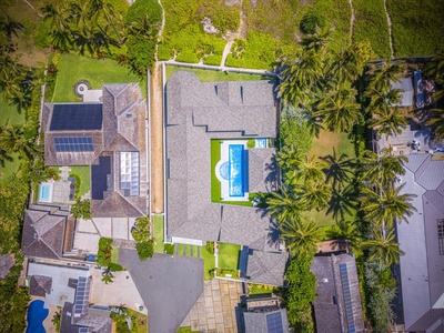 Bird’s-eye view of the gated Kailua Beachfront Estate, showcasing its pool, layout, and lush grounds.