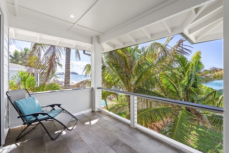 Covered lanai with lounge seating and tropical shade, perfect for relaxing in privacy and comfort.