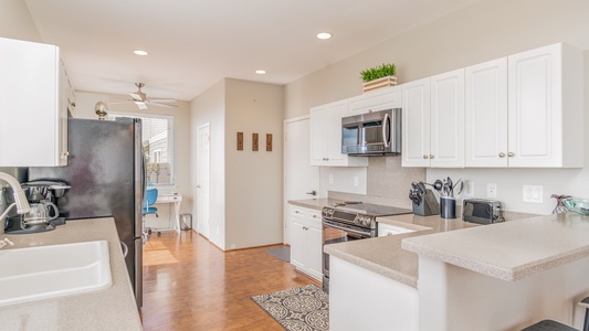 Fully-stocked kitchen with stainless steel appliances.