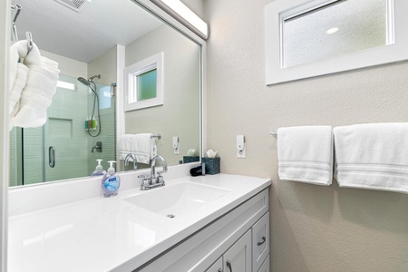 Additional bathroom with wide mirror and spacious counter space.