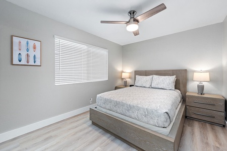 Upstairs bedroom #1 with queen bed, ceiling fan, and plenty of natural light.