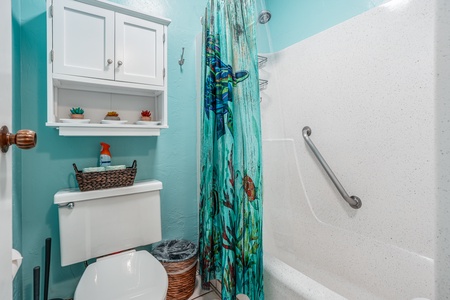 Enjoy a refreshing rinse after beach days in this colorful, island-inspired bathroom featuring a combo tub and shower setup.