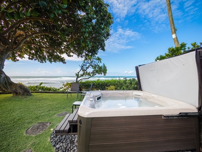Private outdoor hot tub with ocean views, ideal for relaxing soaks under the tree's shade.
