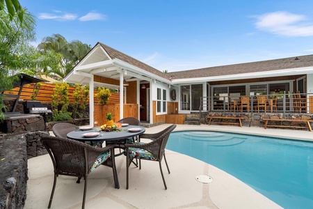 Relax by the pool with a tropical drink at Manukai Hale, surrounded by lush greenery.