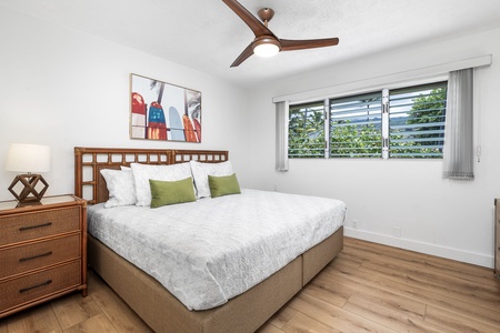 Crisp linens and ceiling fan comfort complete this inviting guest room with lush garden views.