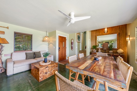 Unwind in your tropical living space featuring natural wood tones, comfortable seating, and a cooling ceiling fan overhead.