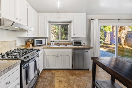 The bright kitchen has direct access to the backyard, making it easy to step outside and dine outdoors.