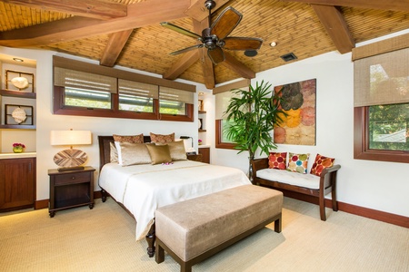 Upstairs guest room with warm textures, natural light, and tropical garden views.