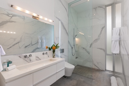 Bathroom 5 features a sleek marble design, complete with a spacious walk-in shower