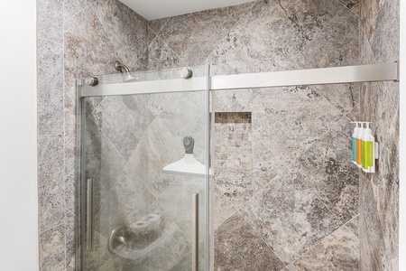 Refresh in a spacious walk-in shower, with textured stone and a calming, spa-like feel.