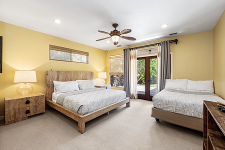 Ground-floor bedroom with a king-sized bed and a double-sized bed, private patio access, and an inviting ambiance.