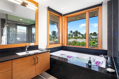 The ensuite bath features designer tile, a deep tub, and panoramic windows.
