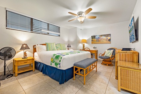 Unwind in Papakea K-105’s serene bedroom with a plush king bed and soft seating for quiet moments.