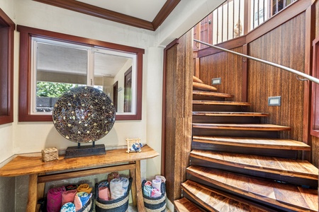 Welcoming foyer with tropical accents and wood staircase—setting the tone for a stylish coastal stay.