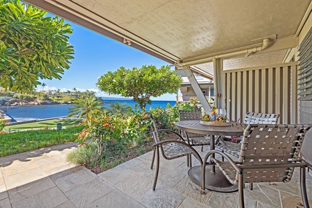 The lanai offers a shaded dining area with stunning ocean views, perfect for enjoying meals al fresco in the refreshing island breeze.