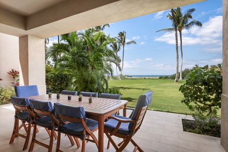 Primary lanai w/ocean view & tropical foliage.