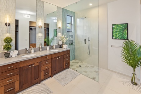 Luxurious en-suite bath with dual vanity and a glass-enclosed rain shower.