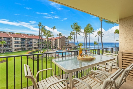 The bright living area offers comfortable seating, a large TV, and direct access to the lanai with ocean views, perfect for relaxing or entertaining.