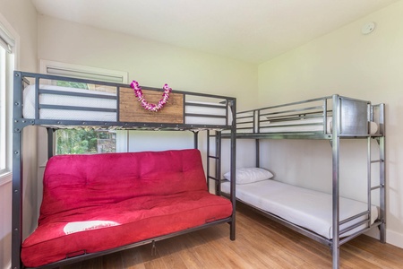 Family-friendly bunk room at Pohaku Villa with futon seating and twin-over-twin setup for kids or extra guests.