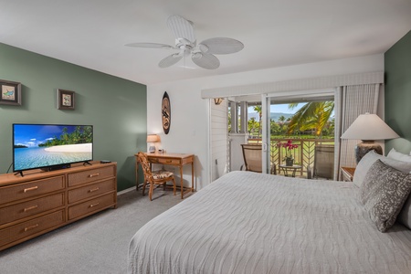 Primary bedroom includes a flat-screen TV, dresser, and cozy desk nook—perfect for remote work or island planning.
