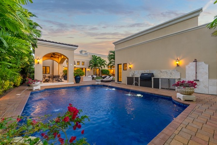 Private pool flanked by vibrant tropical flowers.