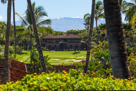 View across lush tropical gardens toward the Hualalai Club Shop & Miller and Lux Restaurant